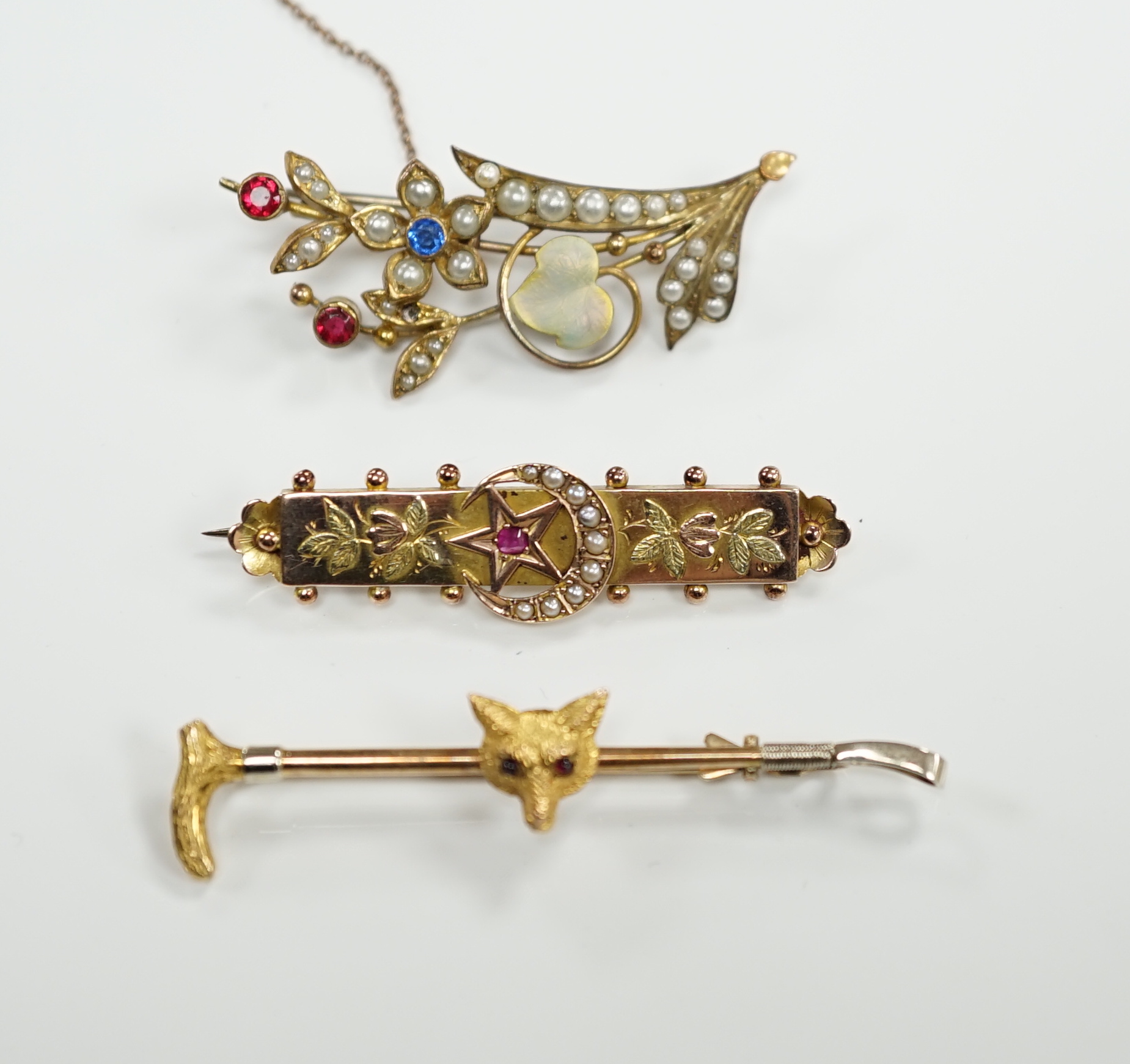 A 9ct and gem set fox head and riding crop bar brooch, 56mm, an Edwardian 9ct gold and gem set bar brooch and a rolled gold bar brooch.